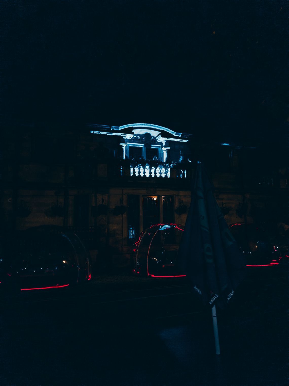 Dark photo of lit balcony, glasgow at night